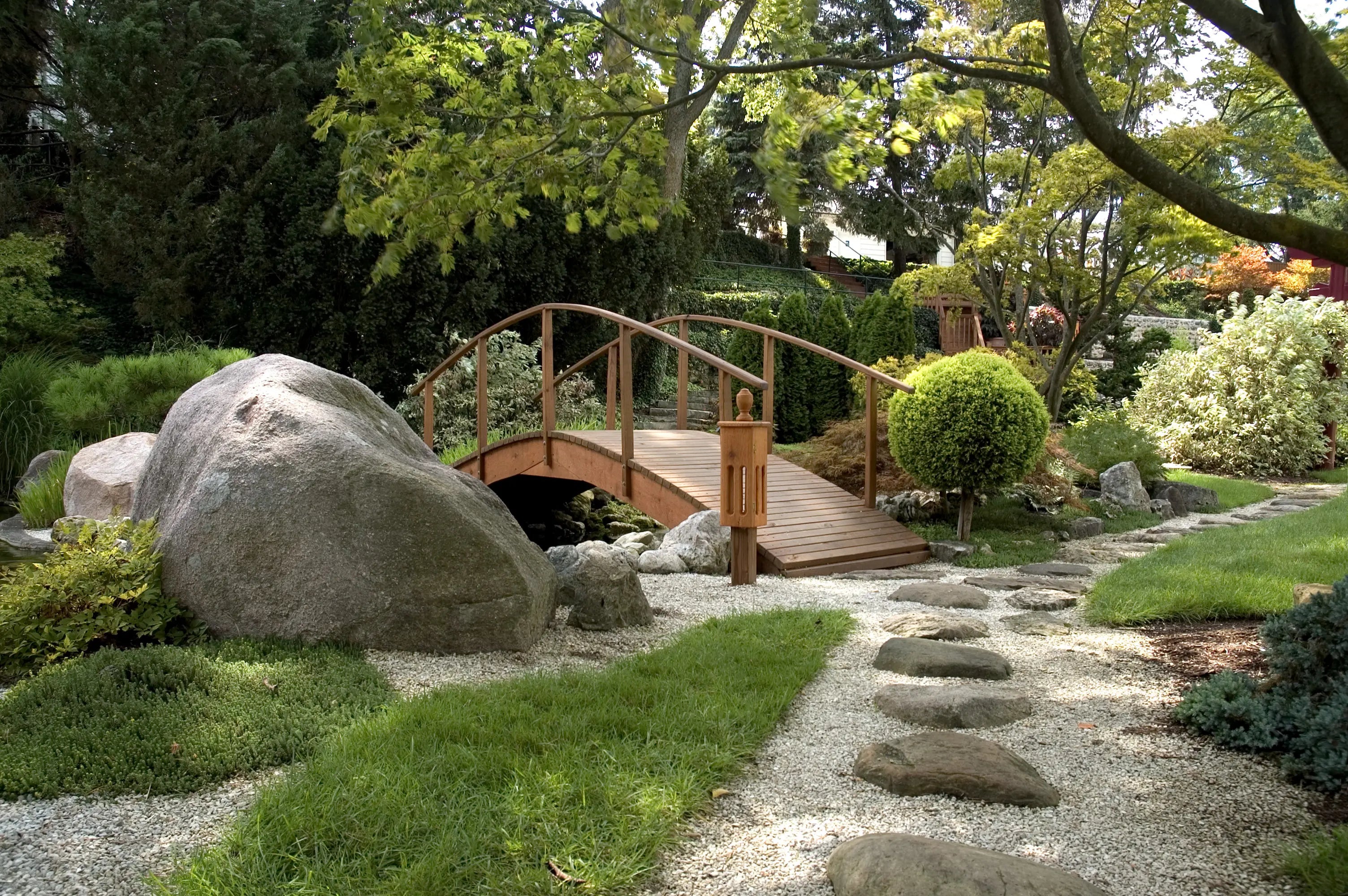 zen garden with a bridge, rocks, moss and gravel