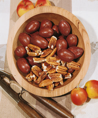 Kanza Pecans, a dish of brown shelled and deshelled pecans
